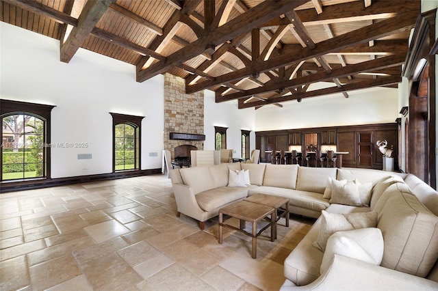 10101 SW 60th Ct, Pinecrest, FL 33156 - living area featuring high vaulted ceiling, a stone fireplace, stone tile floors, and a wood ceiling with exposed beams