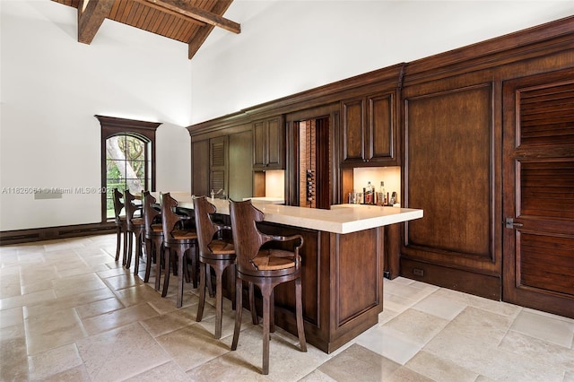 10101 SW 60th Ct, Pinecrest, FL 33156 - indoor wet bar featuring stone tile floors, a high ceiling, and beam ceiling