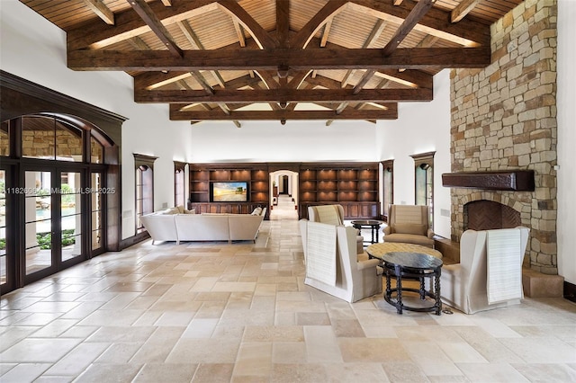 10101 SW 60th Ct, Pinecrest, FL 33156 - living room featuring french doors, high vaulted ceiling, a wooden ceiling with exposed beams, a fireplace, and stone tile floors