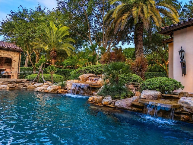 10101 SW 60th Ct, Pinecrest, FL 33156 - view of swimming pool featuring exterior fireplace and a small pond