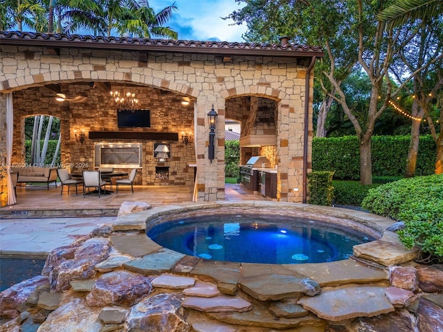 10101 SW 60th Ct, Pinecrest, FL 33156 - view of swimming pool featuring a fireplace, an outdoor kitchen, and a patio area