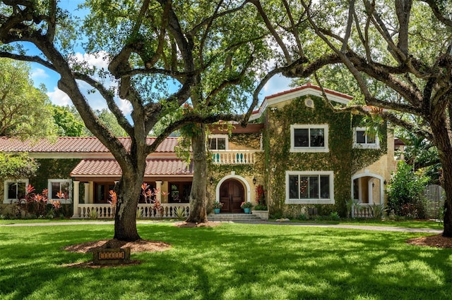 11401 SW 69th Ave, Pinecrest, FL 33156 - view of front of house featuring a front lawn, a tile roof, and covered porch