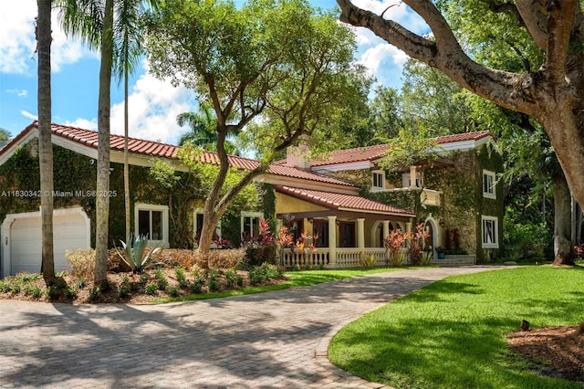 11401 SW 69th Ave, Pinecrest, FL 33156 - view of front of property featuring a tiled roof, a porch, a front yard, and decorative driveway