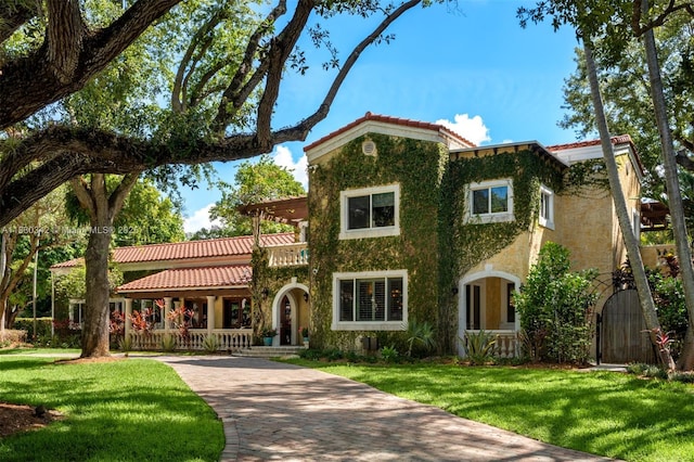 11401 SW 69th Ave, Pinecrest, FL 33156 - view of front of house with covered porch, a tiled roof, and a front yard