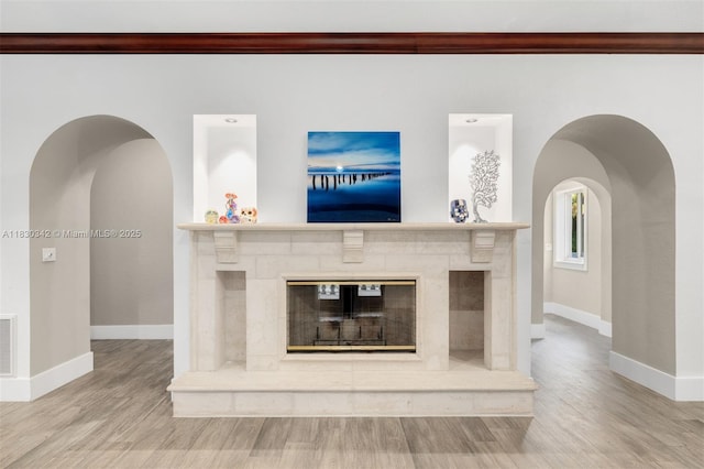 11401 SW 69th Ave, Pinecrest, FL 33156 - unfurnished living room featuring wood finished floors, crown molding, arched walkways, and a glass covered fireplace