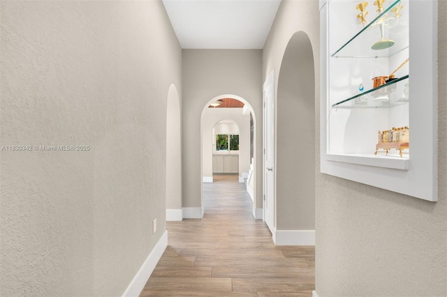 11401 SW 69th Ave, Pinecrest, FL 33156 - hall with arched walkways, wood finished floors, and a textured wall
