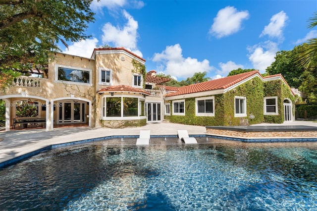 11401 SW 69th Ave, Pinecrest, FL 33156 - rear view of house featuring french doors, a tiled roof, an outdoor pool, and stucco siding