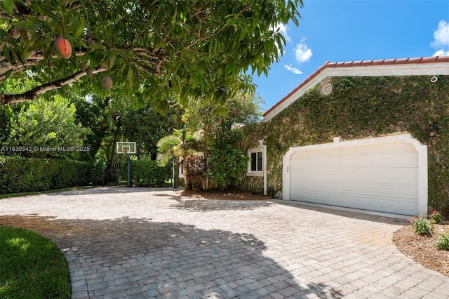 11401 SW 69th Ave, Pinecrest, FL 33156 - view of side of property with decorative driveway, stucco siding, and a garage