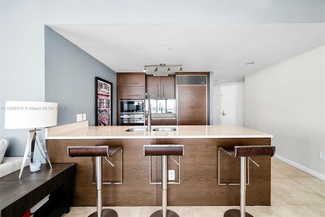 465 Brickell Ave Unit 5302, Miami, FL 33131 - kitchen with a kitchen bar, a peninsula, built in appliances, and light tile patterned flooring
