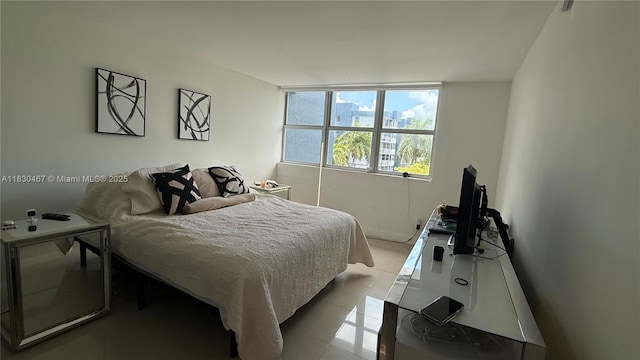 16546 NE 26th Ave Unit 4I, North Miami Beach, FL 33160 - bedroom featuring light tile patterned floors and baseboards