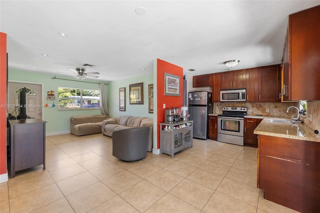 4960 SW 5th St, Margate, FL 33068 - kitchen featuring stainless steel appliances, open floor plan, backsplash, light stone counters, and light tile patterned floors