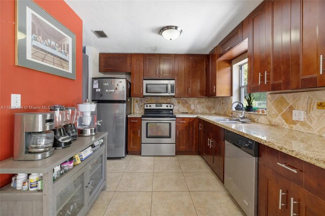 4960 SW 5th St, Margate, FL 33068 - kitchen featuring stainless steel appliances, backsplash, light stone counters, and light tile patterned flooring