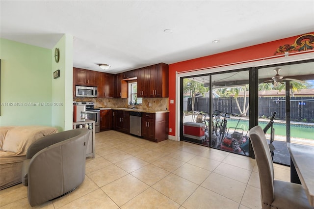 4960 SW 5th St, Margate, FL 33068 - kitchen featuring stainless steel appliances, backsplash, light countertops, light tile patterned flooring, and open floor plan