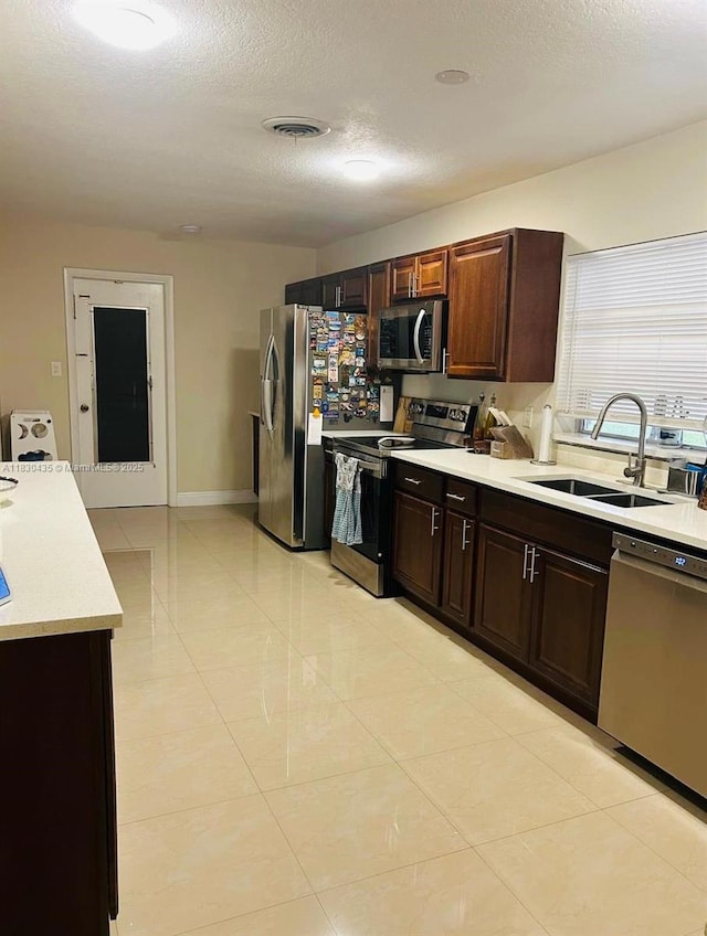 6790 SW 10th Ct, Pembroke Pines, FL 33023 - kitchen featuring appliances with stainless steel finishes, light countertops, a textured ceiling, light tile patterned floors, and dark brown cabinetry