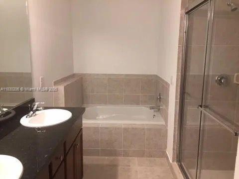 11332 SW 15th St, Pembroke Pines, FL 33025 - full bath featuring double vanity, a garden tub, a stall shower, and tile patterned flooring