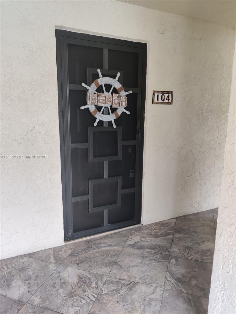 3100 SE Pruitt Rd Unit 104, Port St Lucie, FL 34952 - view of exterior entry with stucco siding