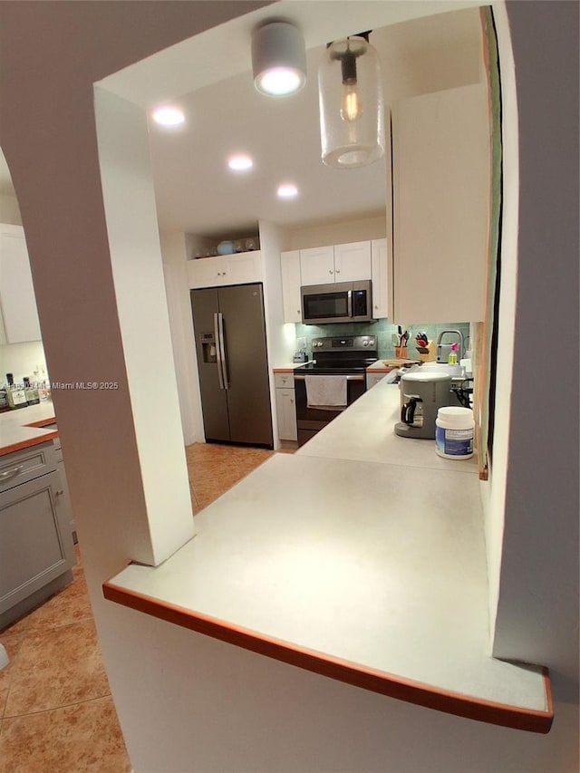 2519 Washington St, Hollywood, FL 33020 - kitchen featuring appliances with stainless steel finishes, arched walkways, light countertops, white cabinets, and recessed lighting
