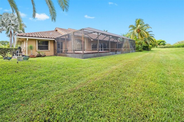 450 NW 195th Ave, Pembroke Pines, FL 33029 - rear view of property with a yard, stucco siding, a tiled roof, and glass enclosure