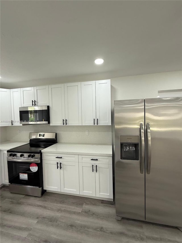 6201 SW 20th Ct, Miramar, FL 33023 - kitchen featuring stainless steel appliances, white cabinets, light countertops, light wood finished floors, and recessed lighting