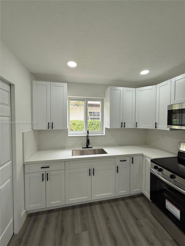 6201 SW 20th Ct, Miramar, FL 33023 - kitchen with appliances with stainless steel finishes, wood finished floors, white cabinetry, recessed lighting, and a textured ceiling