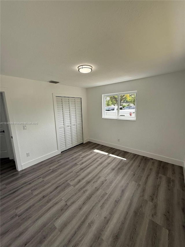 6201 SW 20th Ct, Miramar, FL 33023 - unfurnished bedroom featuring a closet, dark wood-style flooring, and a textured ceiling