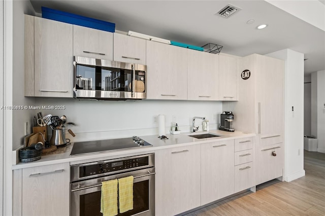 55 SW 9th St Unit 1801, Miami, FL 33130 - kitchen with stainless steel appliances, light countertops, light wood finished floors, and recessed lighting