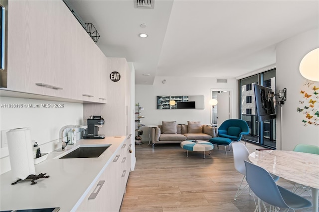 55 SW 9th St Unit 1801, Miami, FL 33130 - kitchen with light countertops, light wood finished floors, open floor plan, white cabinets, and modern cabinets