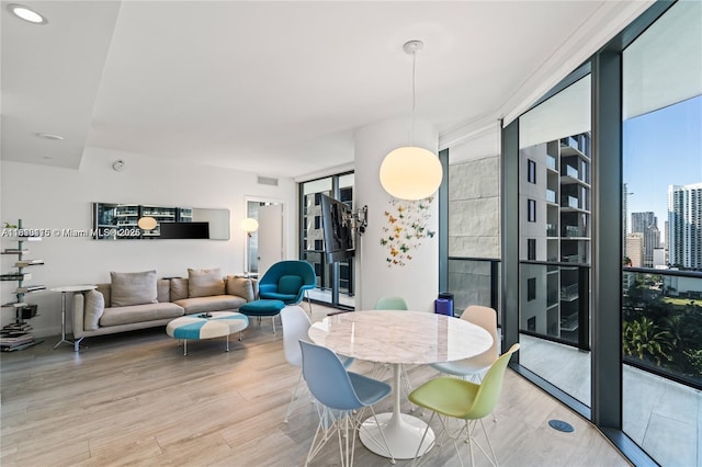 55 SW 9th St Unit 1801, Miami, FL 33130 - dining area featuring expansive windows, light wood-style floors, and a city view