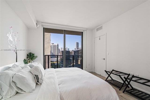 55 SW 9th St Unit 1801, Miami, FL 33130 - bedroom featuring wood finished floors, access to exterior, and a skyline view