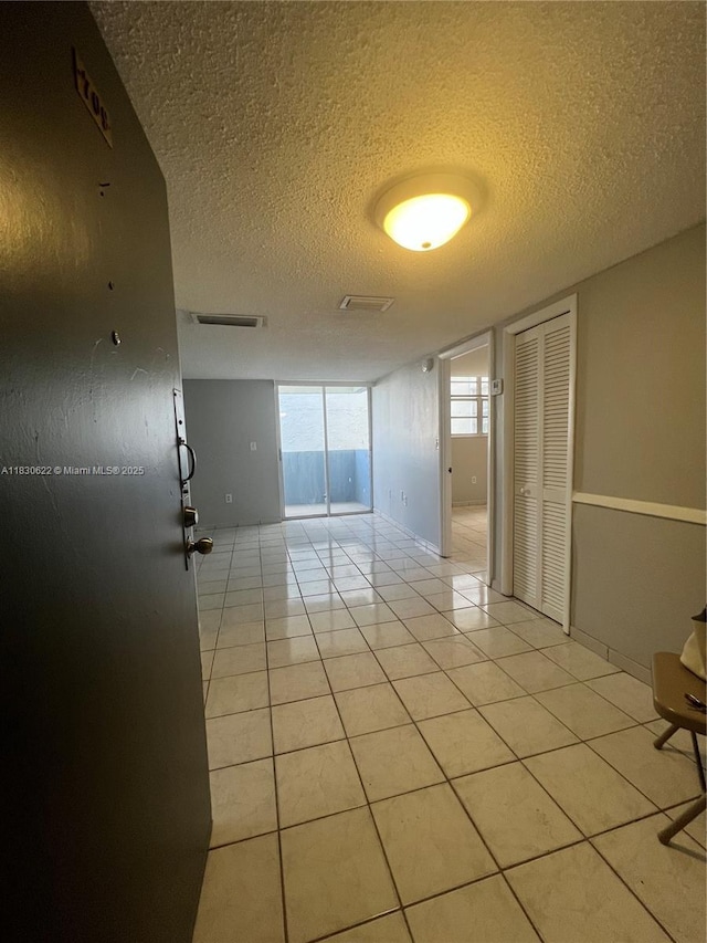 5050 NW 7th St Unit 709, Miami, FL 33126 - spare room with a textured ceiling and light tile patterned floors