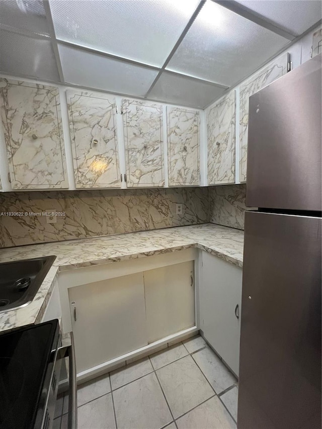 5050 NW 7th St Unit 709, Miami, FL 33126 - kitchen featuring freestanding refrigerator, range with electric stovetop, black electric cooktop, and light tile patterned floors