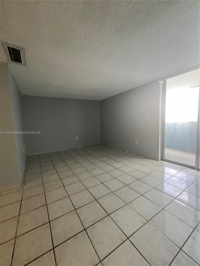5050 NW 7th St Unit 709, Miami, FL 33126 - empty room with a textured ceiling and light tile patterned flooring