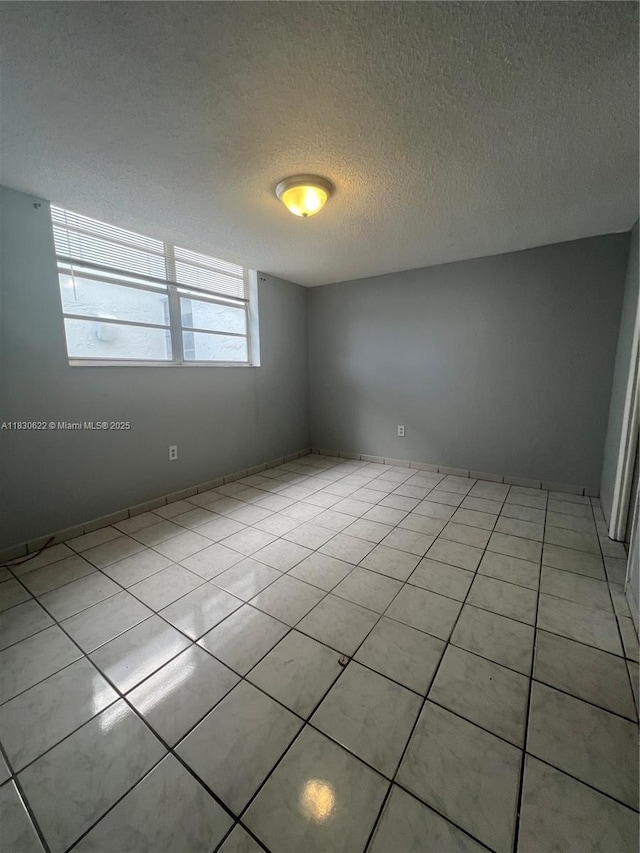 5050 NW 7th St Unit 709, Miami, FL 33126 - spare room with a textured ceiling and light tile patterned flooring