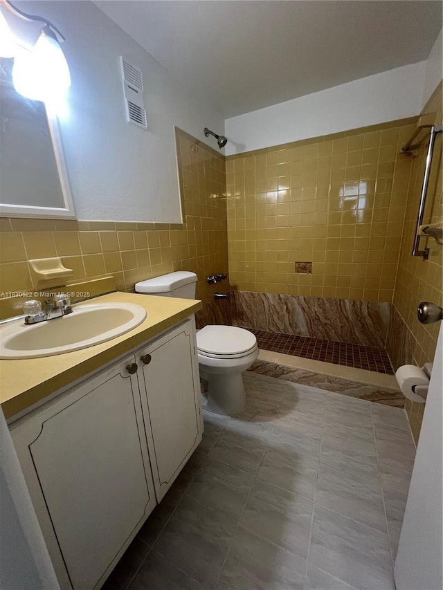 5050 NW 7th St Unit 709, Miami, FL 33126 - bathroom with a tile shower, tile walls, vanity, and tile patterned floors