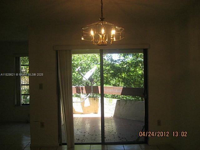 9015 SW 125th Ave Unit N406, Miami, FL 33186 - doorway to outside with tile patterned flooring, a chandelier, and healthy amount of natural light