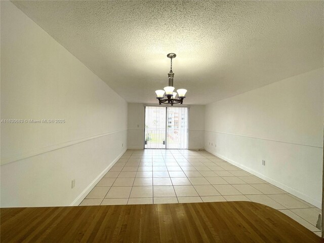 6940 Miami Gardens Dr Unit 1-329, Hialeah, FL 33015 - empty room with a chandelier, light tile patterned flooring, and a textured ceiling