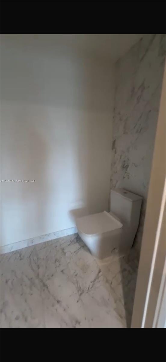 1000 Brickell Plz Unit 2008, Miami, FL 33131 - bathroom featuring toilet and marble look tile flooring