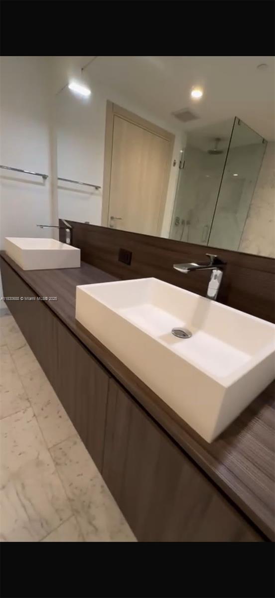 1000 Brickell Plz Unit 2008, Miami, FL 33131 - bathroom with marble finish flooring, double vanity, and a walk in shower