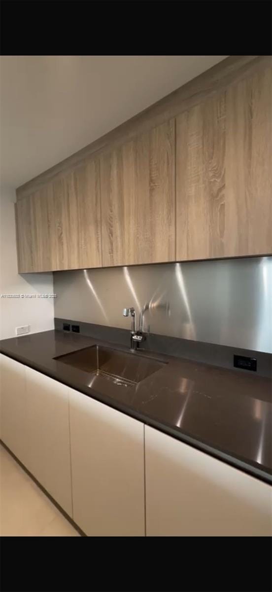 1000 Brickell Plz Unit 2008, Miami, FL 33131 - kitchen with modern cabinets, light brown cabinetry, and dark countertops