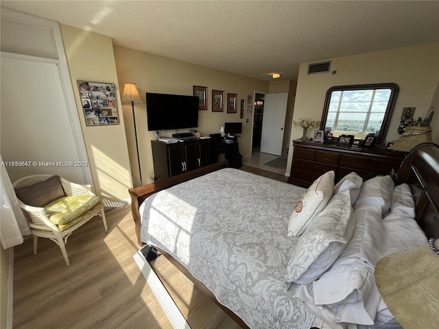 1200 Saint Charles Pl Unit 708, Pembroke Pines, FL 33026 - bedroom with light wood-style flooring and a textured ceiling