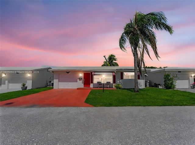 2991 NW 1st Dr, Pompano Beach, FL 33064 - view of front of house with a garage, a yard, driveway, and stucco siding