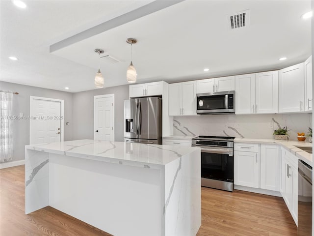 2991 NW 1st Dr, Pompano Beach, FL 33064 - kitchen featuring stainless steel appliances, a kitchen island, recessed lighting, light stone countertops, and light wood-style flooring