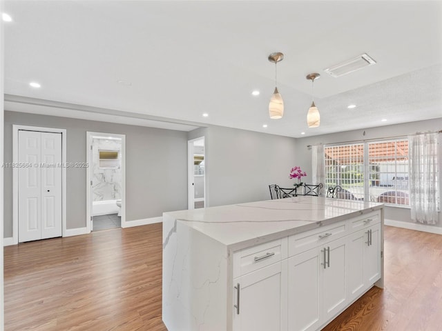 2991 NW 1st Dr, Pompano Beach, FL 33064 - kitchen featuring white cabinets, light wood-type flooring, recessed lighting, decorative light fixtures, and light stone countertops