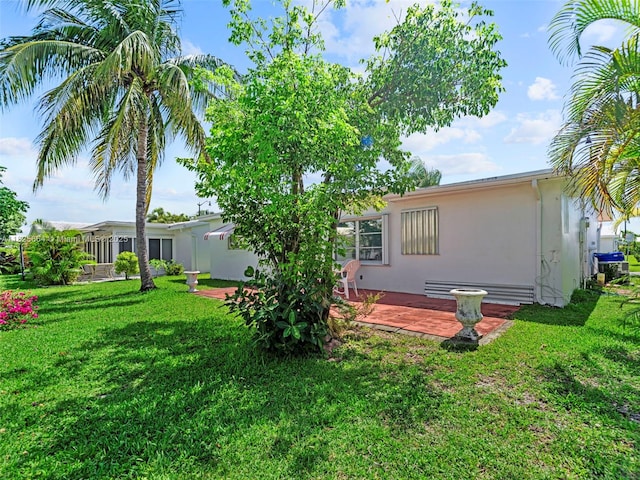 2991 NW 1st Dr, Pompano Beach, FL 33064 - rear view of property featuring stucco siding, a yard, and a patio area