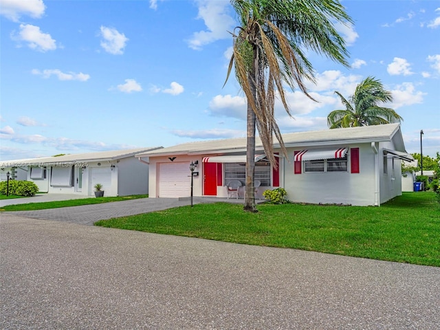 2991 NW 1st Dr, Pompano Beach, FL 33064 - single story home with a garage, asphalt driveway, a front yard, and stucco siding