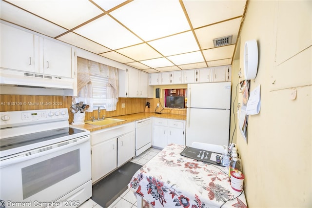 3531 Inverrary Dr Unit 101, Lauderhill, FL 33319 - kitchen featuring white appliances, under cabinet range hood, light countertops, white cabinets, and a drop ceiling
