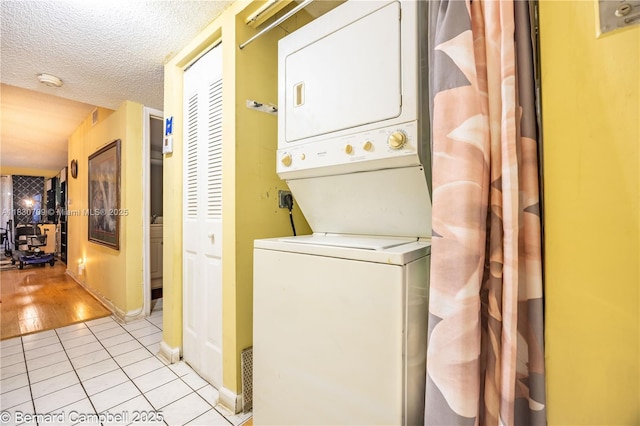 3531 Inverrary Dr Unit 101, Lauderhill, FL 33319 - laundry room with stacked washer and clothes dryer, light tile patterned floors, and a textured ceiling