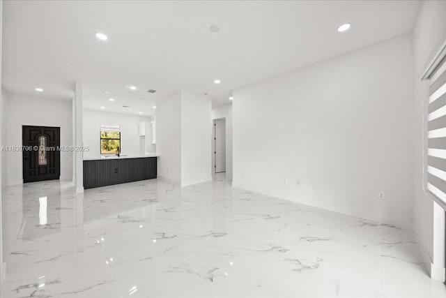 1212 Edelweiss St E, Lehigh Acres, FL 33974 - unfurnished living room featuring light marble finish flooring and recessed lighting