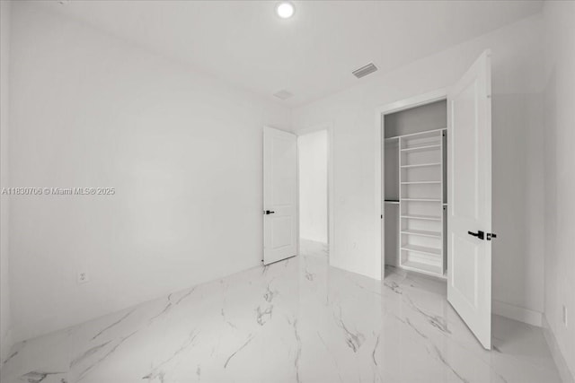 1212 Edelweiss St E, Lehigh Acres, FL 33974 - unfurnished bedroom with light marble finish floors, recessed lighting, a closet, and a walk in closet