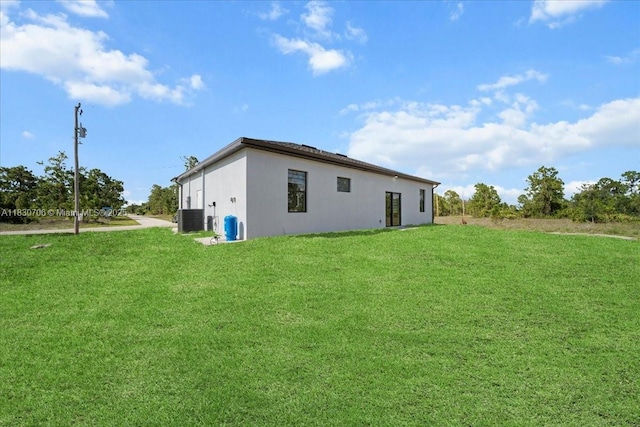 1212 Edelweiss St E, Lehigh Acres, FL 33974 - rear view of house featuring stucco siding and a yard